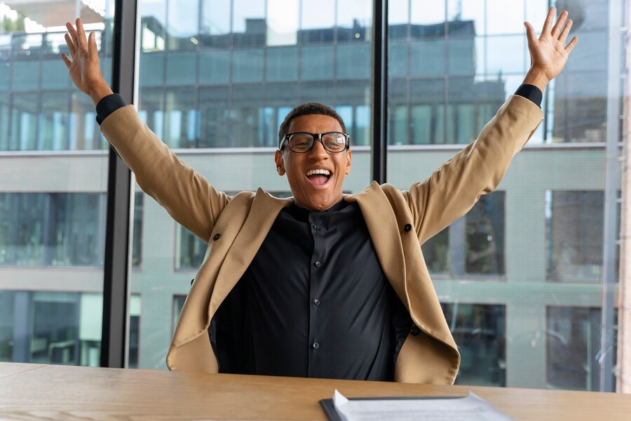 A confident Black man holding an alarm clock in one hand and giving a thumbs-up with the other, standing in front of a wall with sticky notes, symbolizing personal effectiveness and time management.