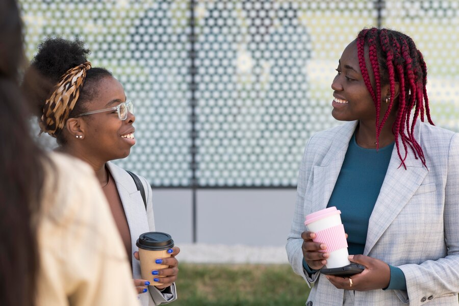 Two african female professionals bonding and networking over coffee